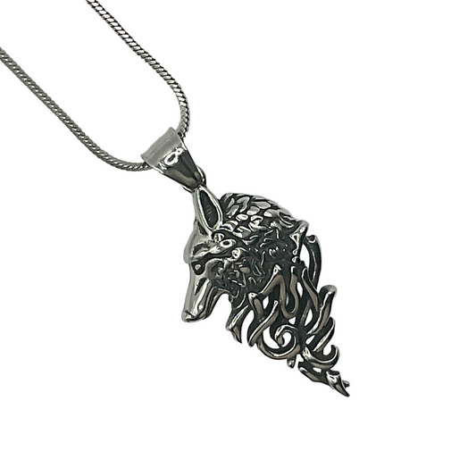 A silver tone pendant necklace featuring an intricately detailed wolf head design, suspended from a matching silver chain against a plain light gray background.