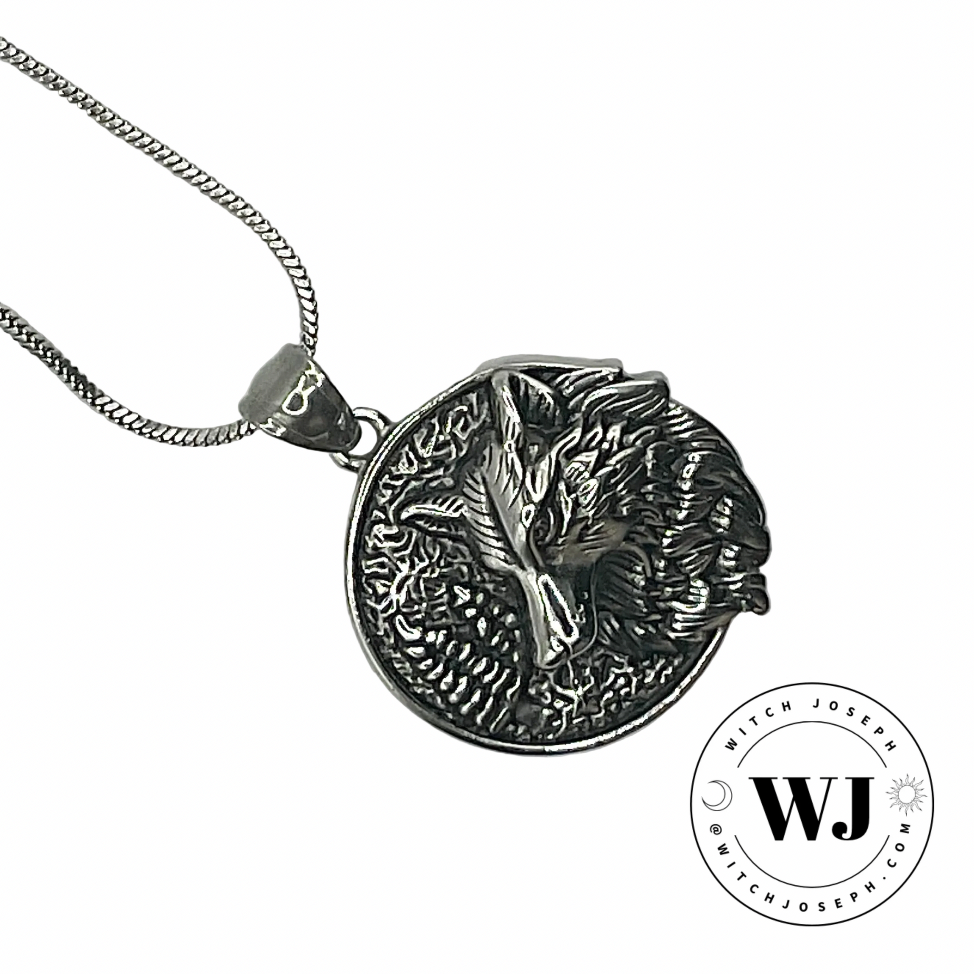 Silver tone pendant with wolf design displayed on a white background, featuring the Witch Joseph logo