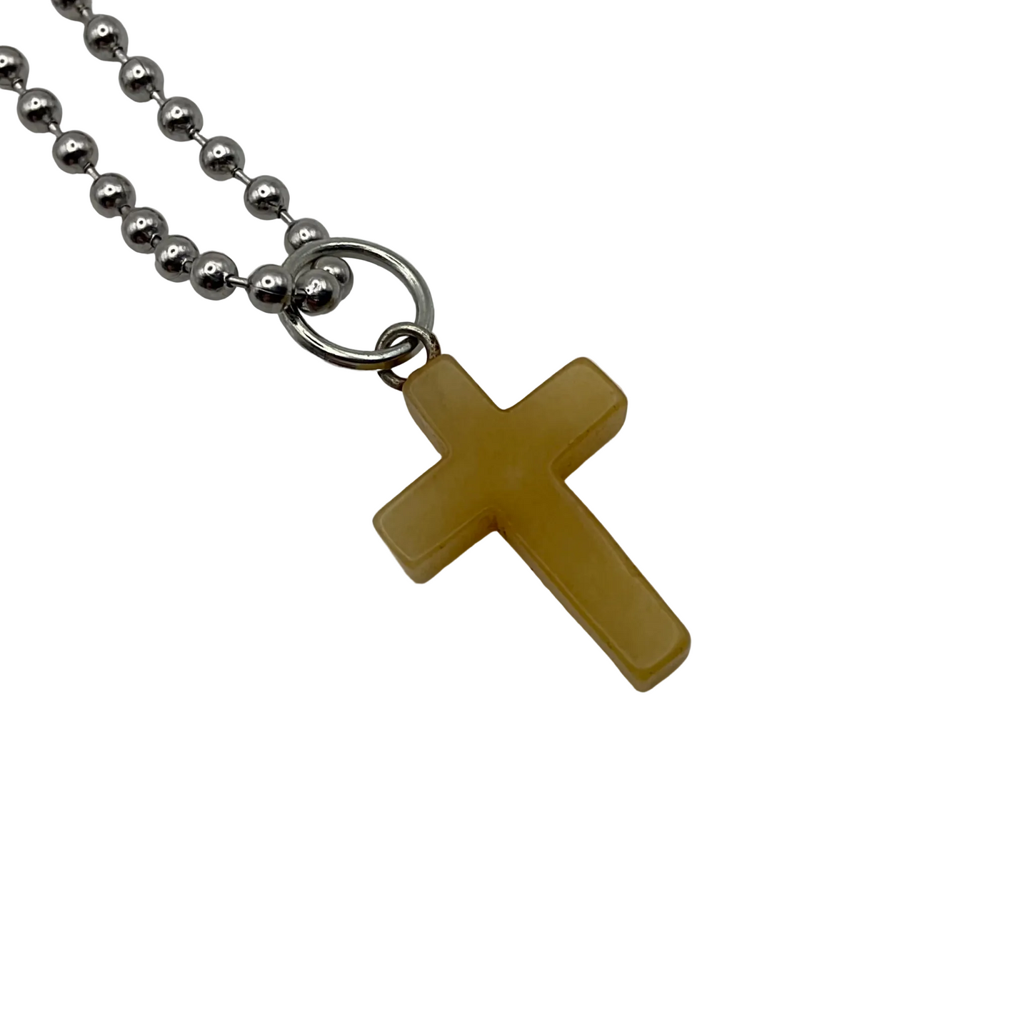 Yellow cross pendant on a silver tone ball chain against a white background
